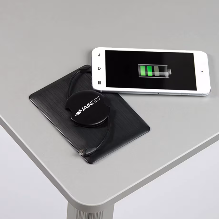 Induktionsladefeld in der Thekenplatte mit aufgelegtem Smartphone