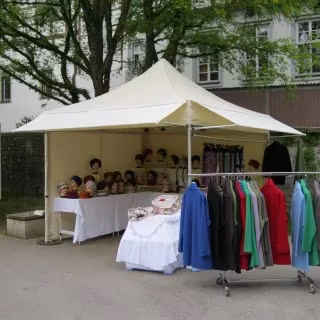 Marktstand mit cremefarbenem Vordach und Kleiderständer